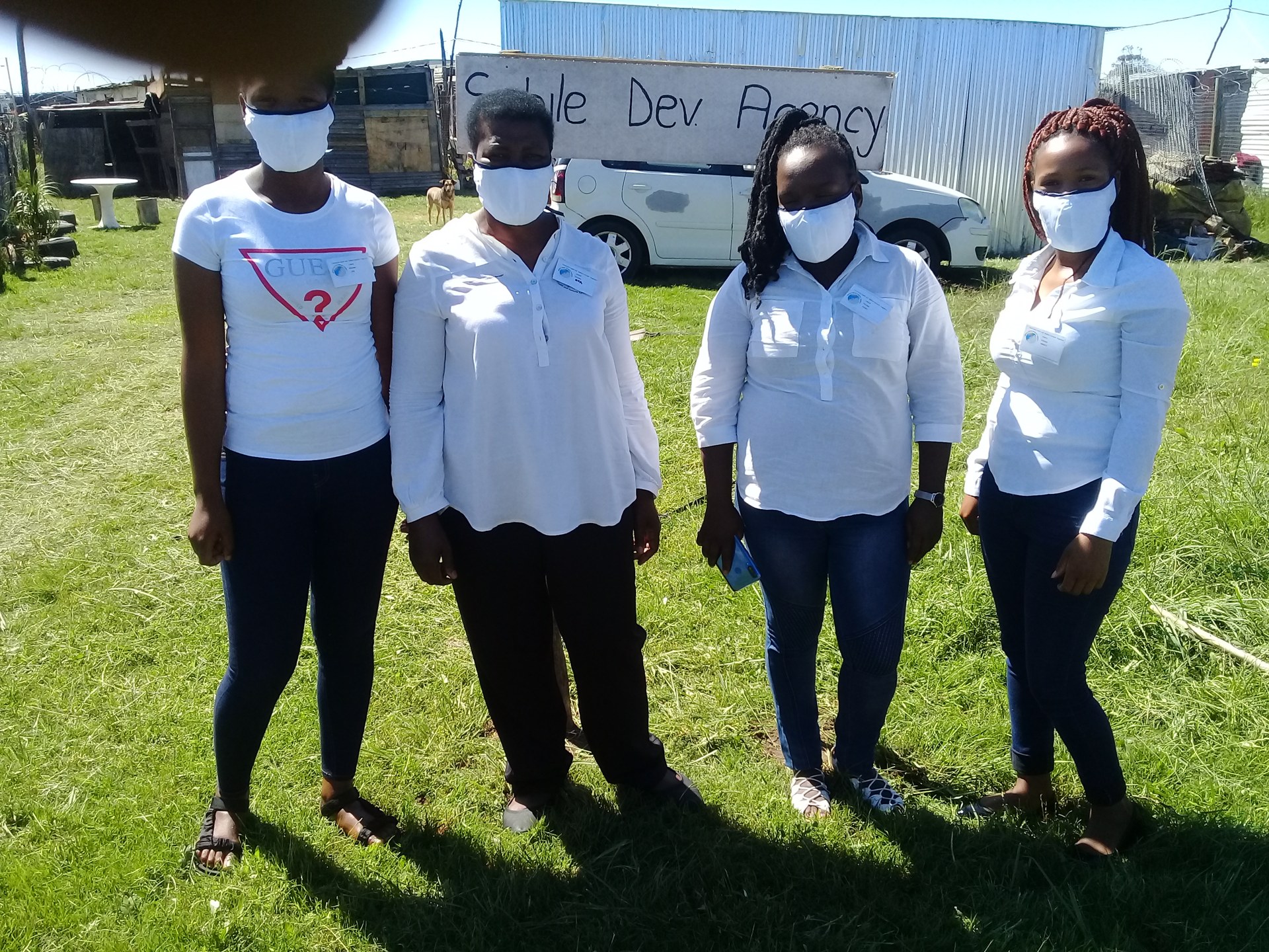 Siphile Development Agency team members standing at the SDA sign in Kuyga, Gqeberha